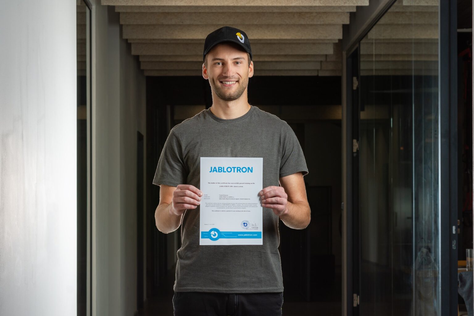 Instalator trzyma certyfikat ukończenia szkolenia Akademii Instalatora JABLOTRON